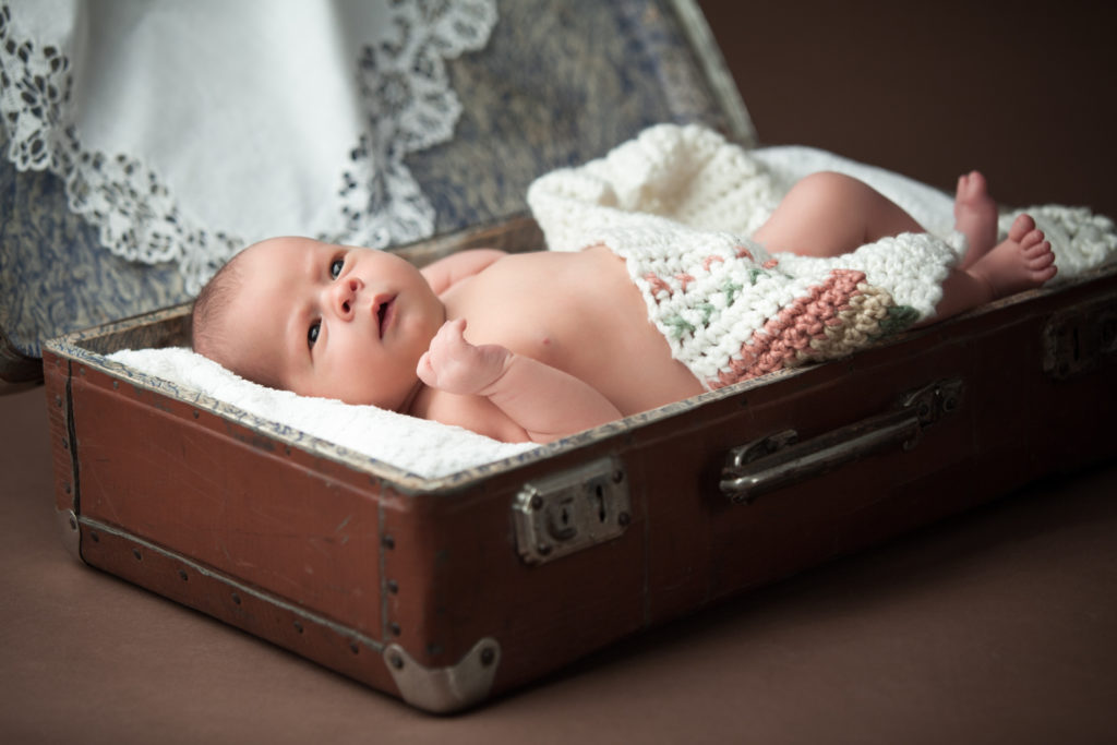 7 days old baby lay in vintage suitcase