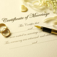 Certificate of marriage with a pen and gold rings.Click on the link below to see more of my wedding and party image.
